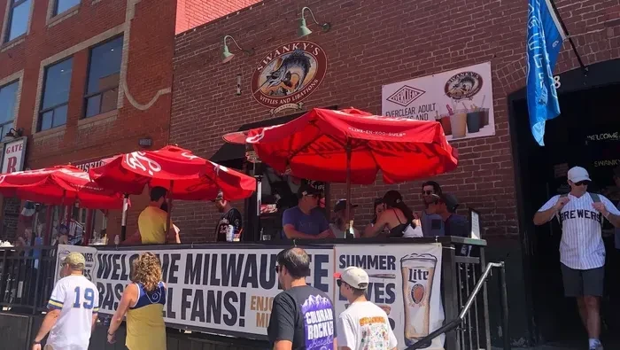 Swanky's red brick restaurant patio with red umbrellas and baseball fans.