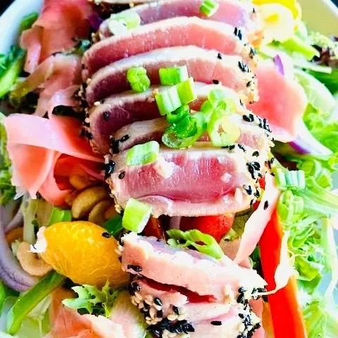 Seared tuna salad with sesame-crusted tuna, lettuce, orange, and ginger.