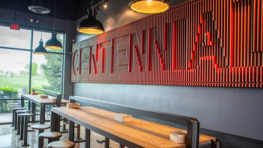 Interior of a modern restaurant featuring red slat 'CENTENNIAL' wall art.