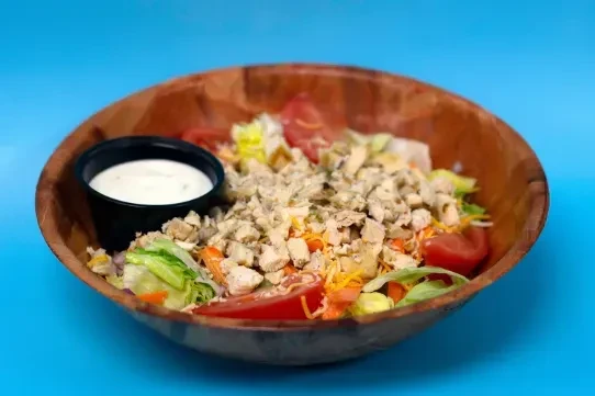 Mixed green salad with chicken, cheddar, tomatoes, and ranch dressing.