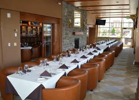 Elegant private dining room with set table, armchairs, and fireplace.