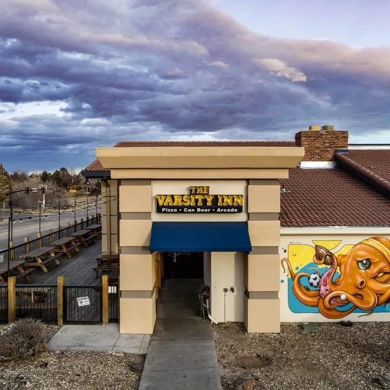 The Varsity Inn: entrance, patio, and octopus mural under cloudy sky.