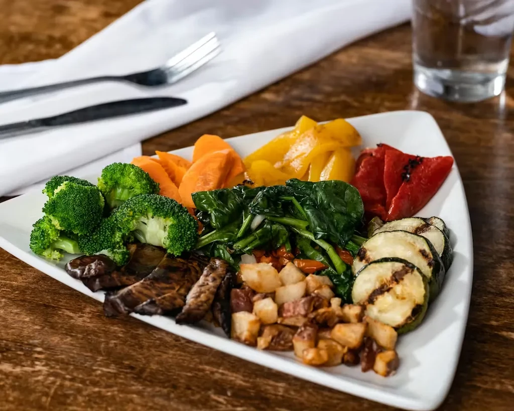 Healthy, vibrantly colored plate of cooked vegetables and roasted potatoes.