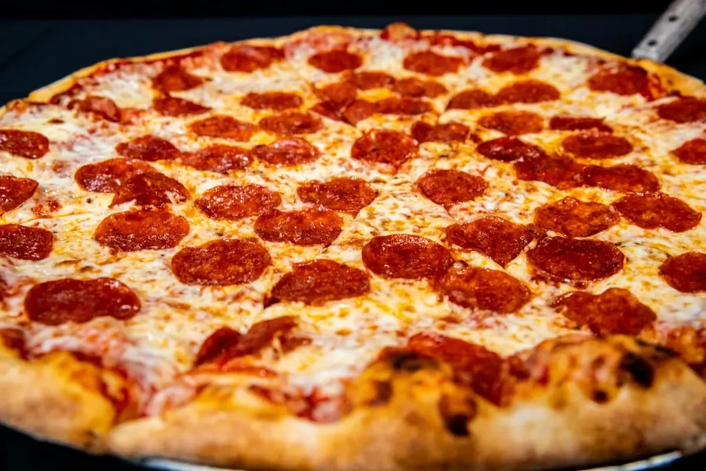 Close-up of hot pepperoni pizza with bubbling cheese and golden crust.