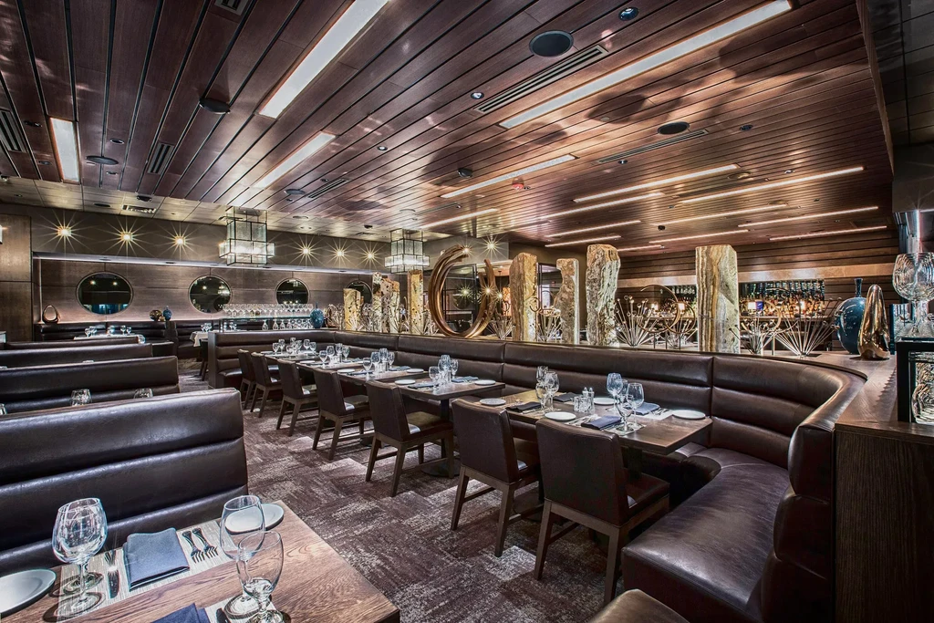 Modern, upscale restaurant dining area with luxurious decor and warm lighting.