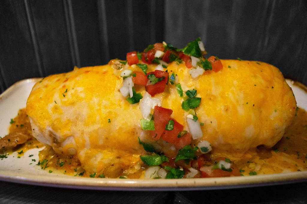 Large burrito smothered in cheese, topped with pico de gallo.