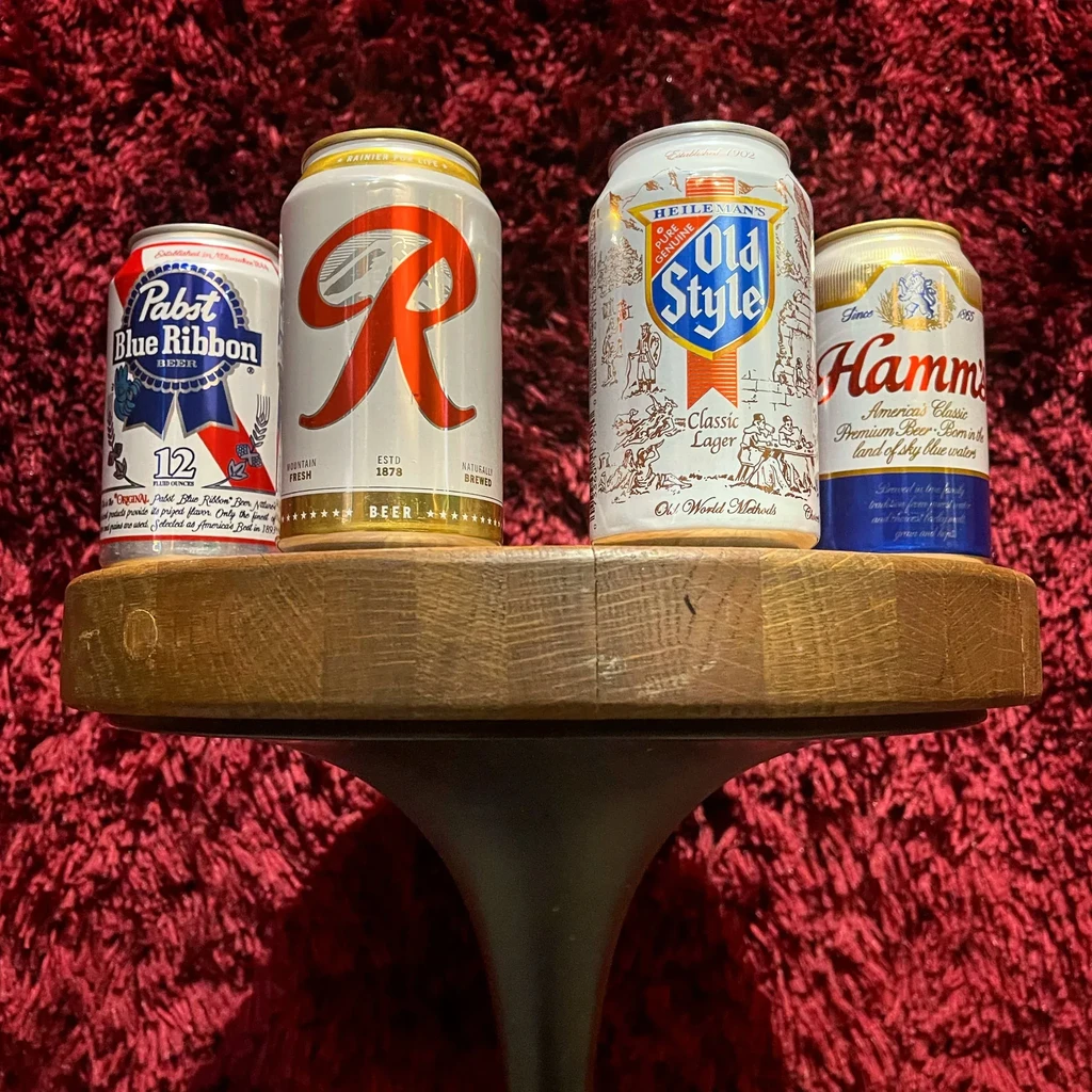 Pabst, Rainier, Old Style, Hamm's beer cans on a wooden stand.
