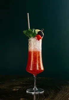 Vibrant red cocktail with crushed ice, mint, lime, and berries.