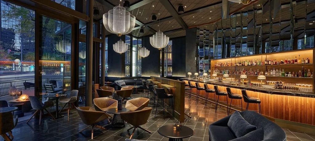 Sophisticated modern bar lounge with city view at night.
