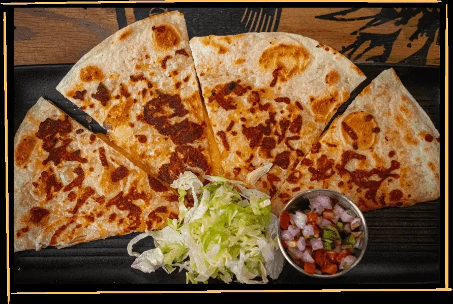 Five grilled cheese quesadilla slices with lettuce and pico de gallo.