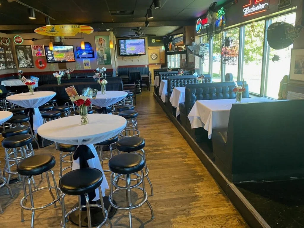 Event-ready sports bar interior with decorated tables, TVs, and wall memorabilia.