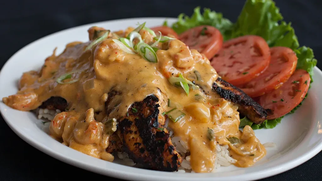 Grilled protein, white rice, creamy crawfish sauce, and a side salad.