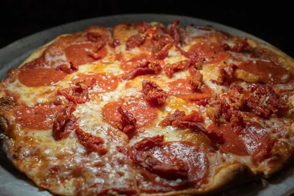 Freshly baked pepperoni pizza with melted mozzarella and red toppings.