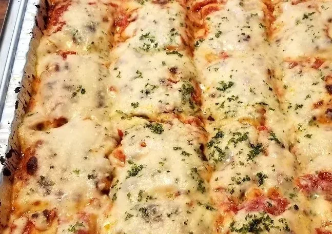 Baked Italian casserole with golden bubbling cheese, red sauce, and herbs.