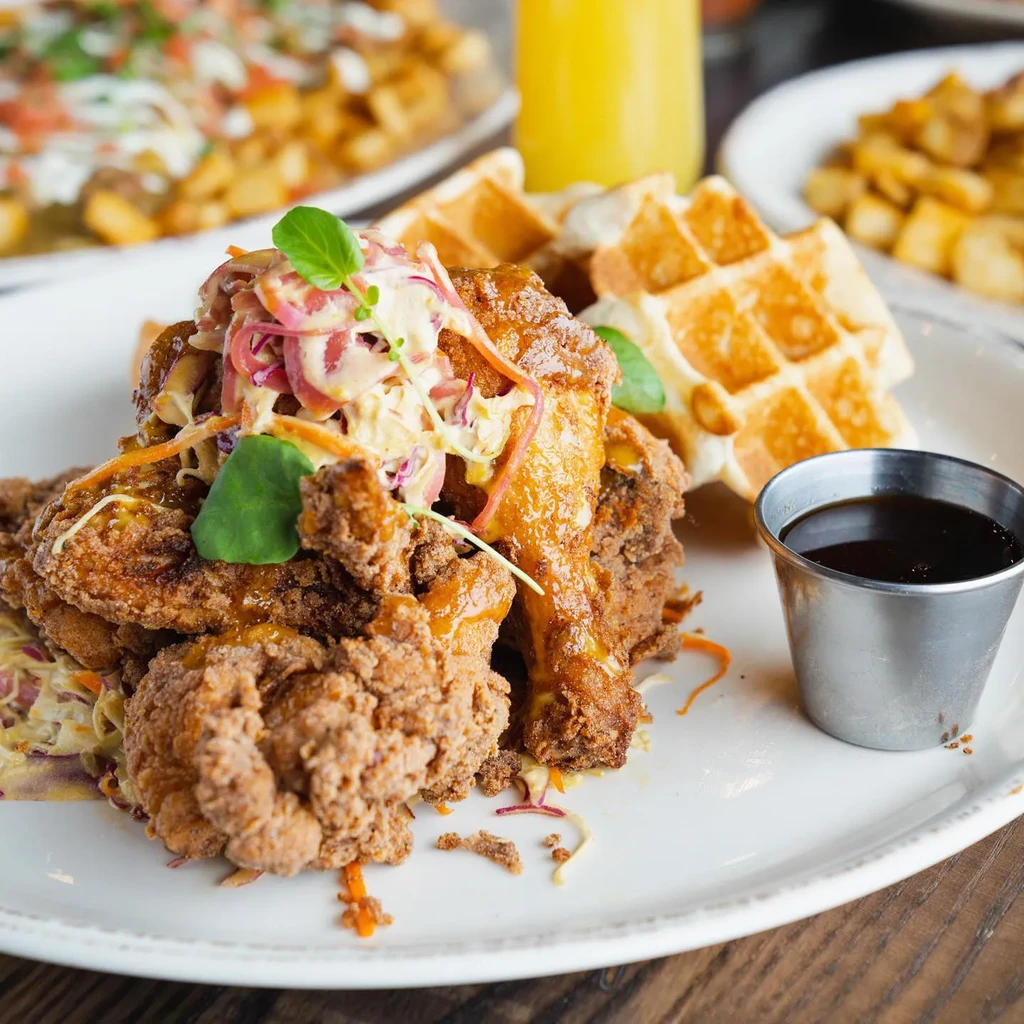 Fried chicken, creamy slaw, Belgian waffles, and a syrup cup.