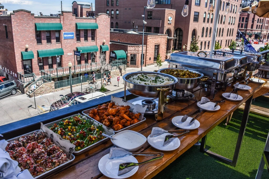 Vibrant outdoor buffet with diverse food overlooking a bustling city.