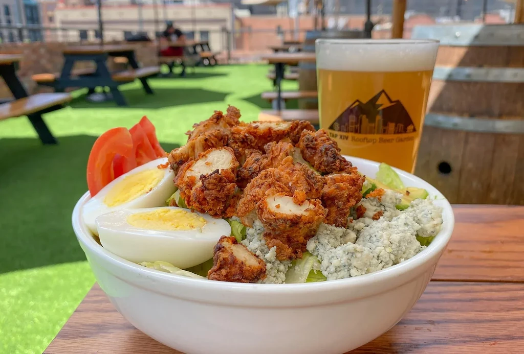 Fried chicken salad with blue cheese, beer, on a rooftop.