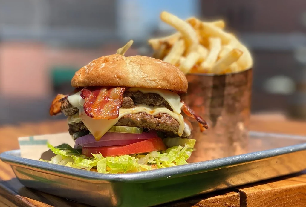 Double cheeseburger with bacon, lettuce, tomato, onion, pickles, and fries.