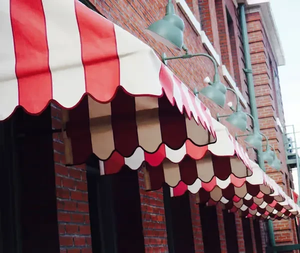 Red and white striped awnings, brick wall, and green dome lights.