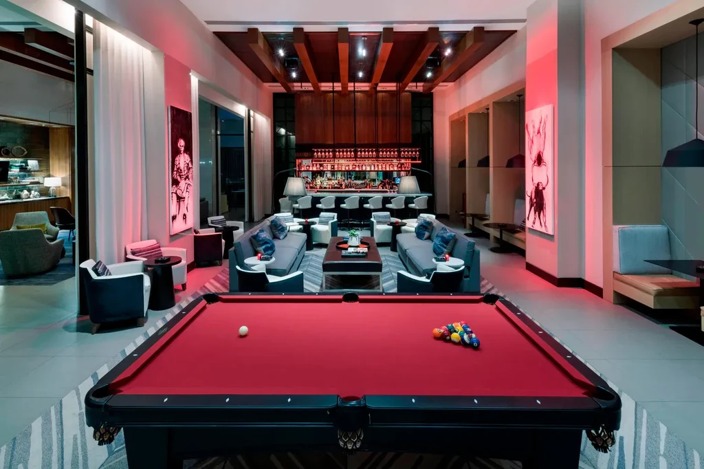 Upscale, red-lit lounge with a red-felt pool table and full bar.