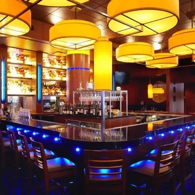Stylish bar with blue LED counter, warm back-bar, and distinctive lamps.
