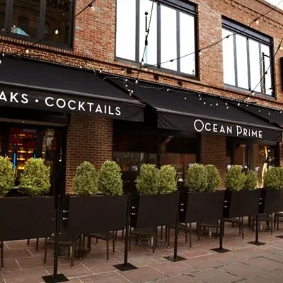 Ocean Prime restaurant, brick exterior with awnings and outdoor seating.