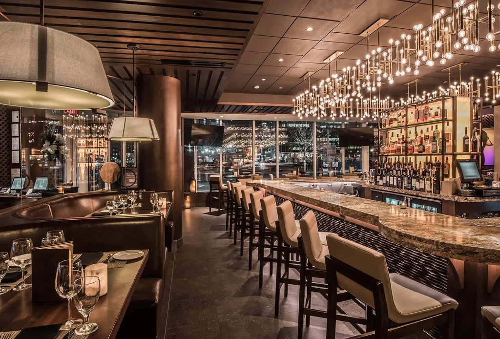 Warmly lit upscale restaurant with elegant dining booths and a well-stocked bar.