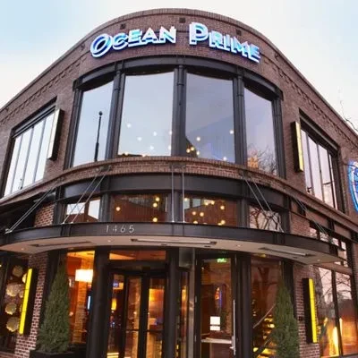 Ocean Prime restaurant building with curved brick and glass facade.