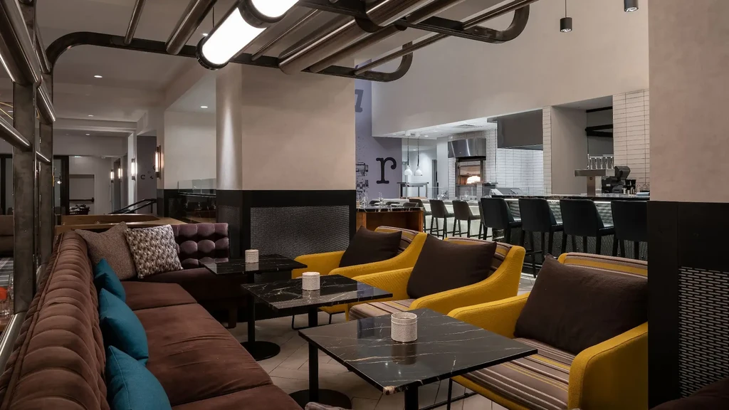 Modern restaurant interior with lounge seating and a glowing brick oven.