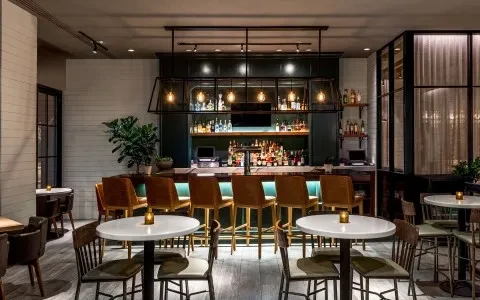 Empty modern bar and restaurant with illuminated liquor bottles.