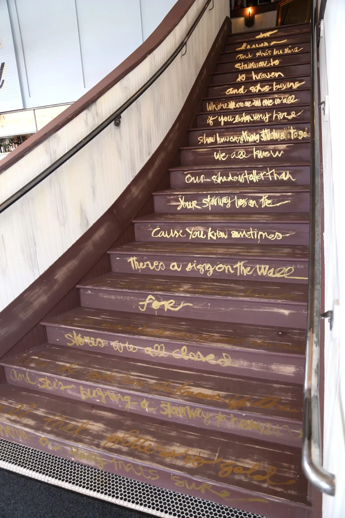 Dark staircase with golden 'Stairway to Heaven' lyrics on risers.