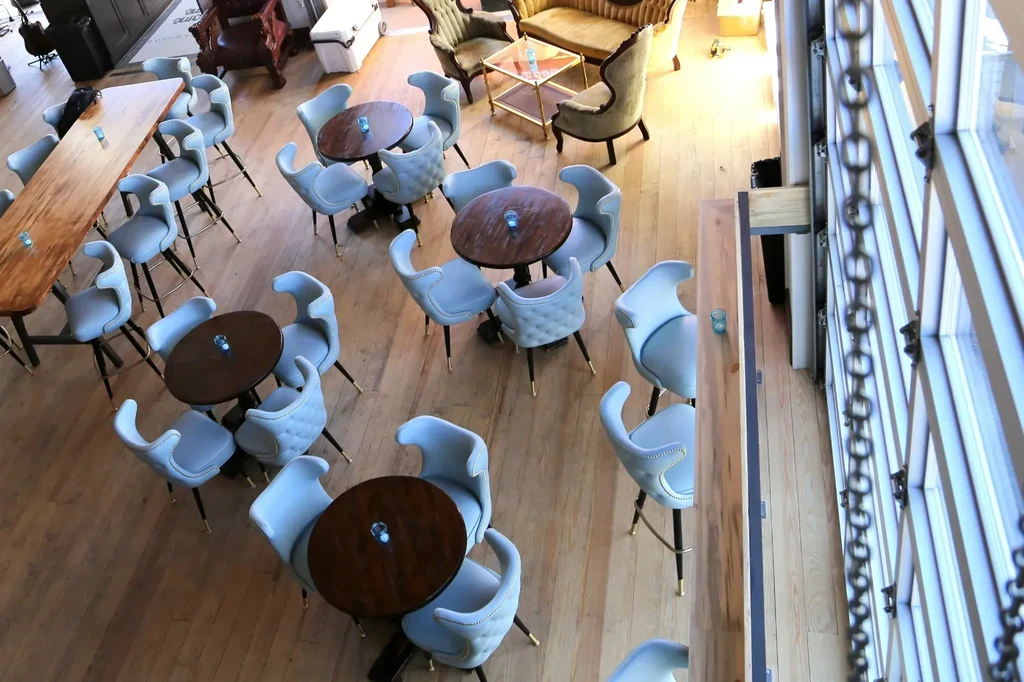 Modern restaurant interior with diverse seating and a window with chains.