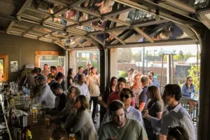 Lively bar interior with a large crowd and an open-air design.
