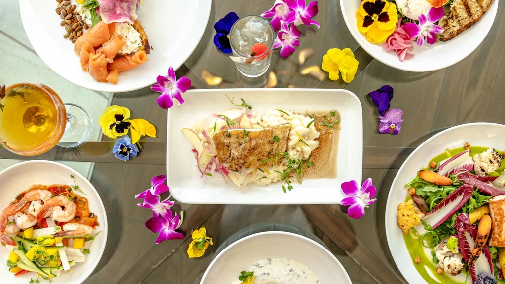 Overhead view of a diverse, beautifully plated food and drink spread.