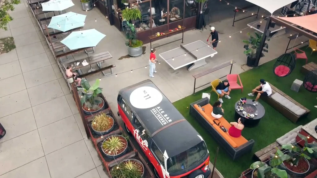 Elevated view of a lively outdoor bar with dining, games, lounge areas.