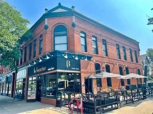 Corner brick building with La Sooche wine bar and outdoor patio.