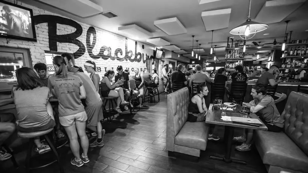 Black and white photo of Blackby BLIND HOUS restaurant, bustling with patrons.