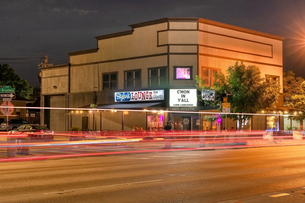Skylark LOUNGE at night, bright long-exposure vehicle light trails.