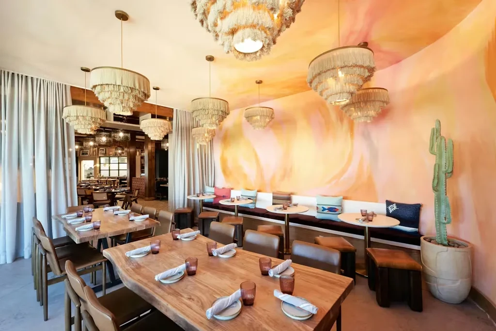 Warm-toned restaurant dining area featuring desert-inspired mural and natural materials.