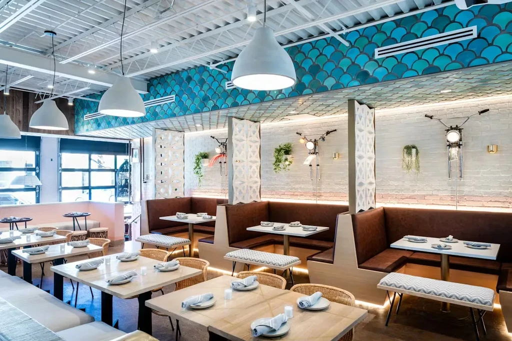 Bright, modern restaurant interior featuring turquoise walls and diverse seating.