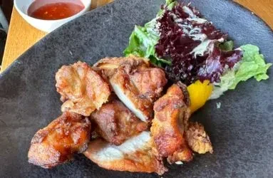 Crispy golden fried meat, salad, lemon, and red dipping sauce.