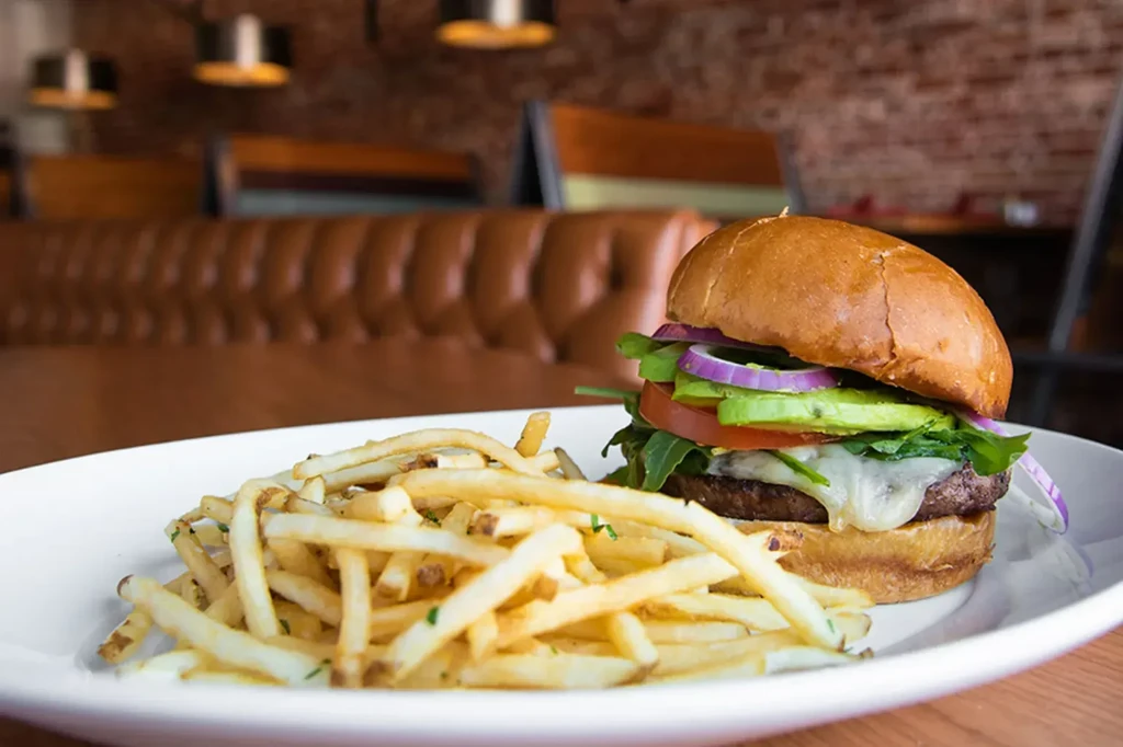 Gourmet burger and fries on a plate in a restaurant.