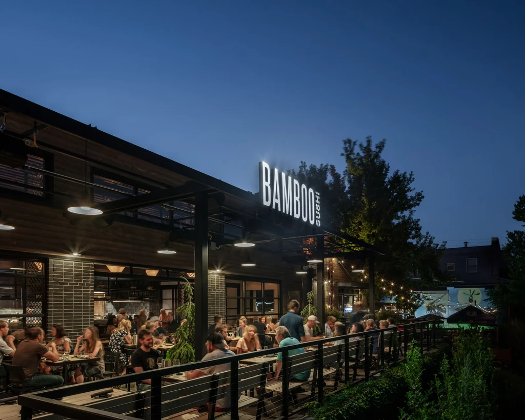 BAMBOO SUSHI's illuminated outdoor dining patio bustling with patrons.