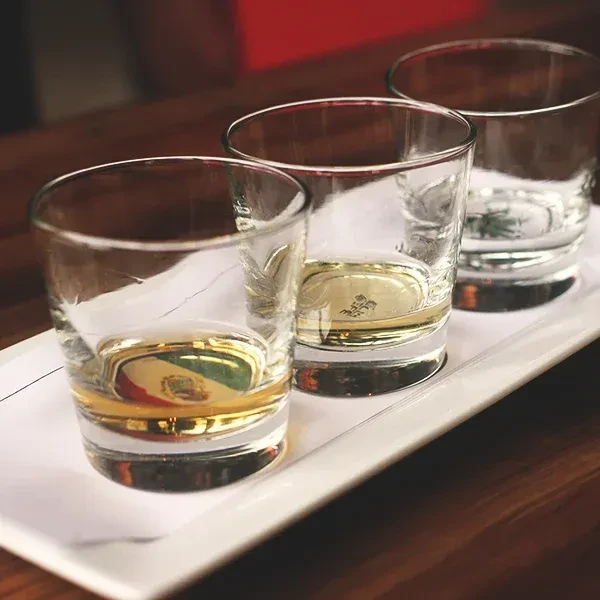 Three shot glasses on a tray, one reflecting the Mexican flag.