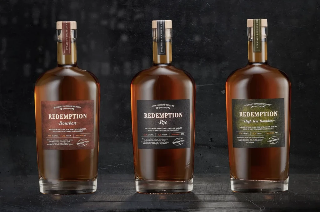 Redemption Bourbon, Rye, and High Rye Bourbon bottles on a dark surface.