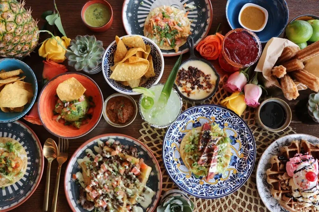 Colorful flat lay of a large Mexican food and drink spread.