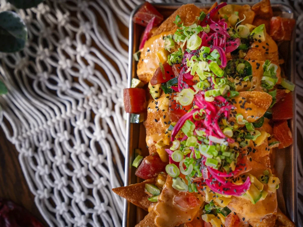 Crispy chips with tuna, orange sauce, pickled onions, and scallions.
