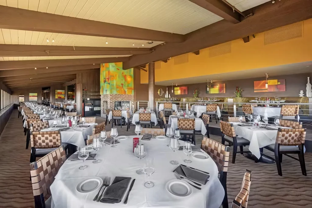 Elegant restaurant dining room featuring set tables, fireplace, and modern art.