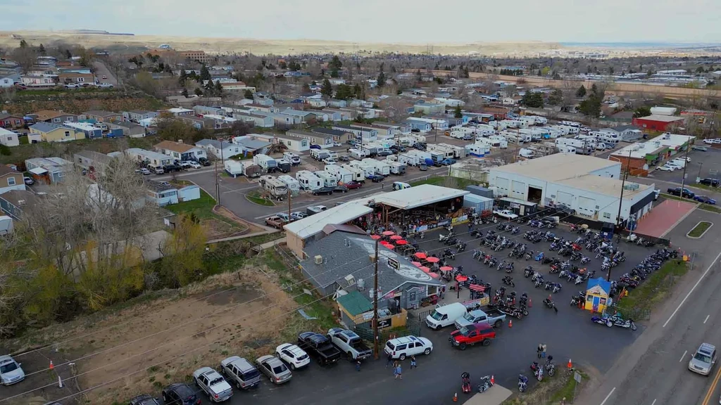Aerial shot of restaurant crowded with motorcycles, next to RV park.