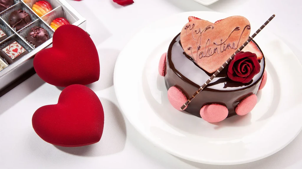 Chocolate cake with "My Valentine" heart, pink macarons, and red rose.